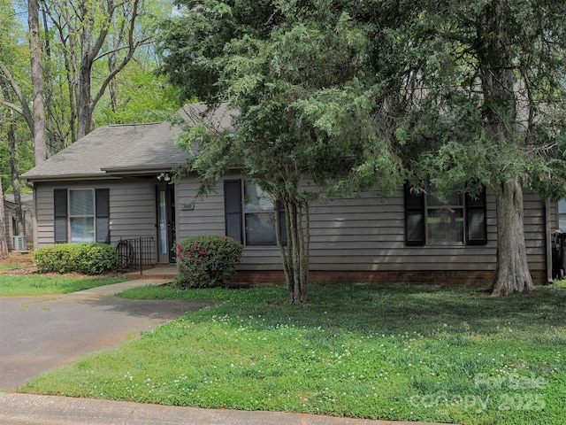 view of front facade featuring a front lawn and roof with shingles