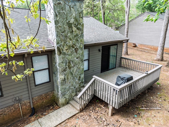 exterior space featuring a deck and a shingled roof