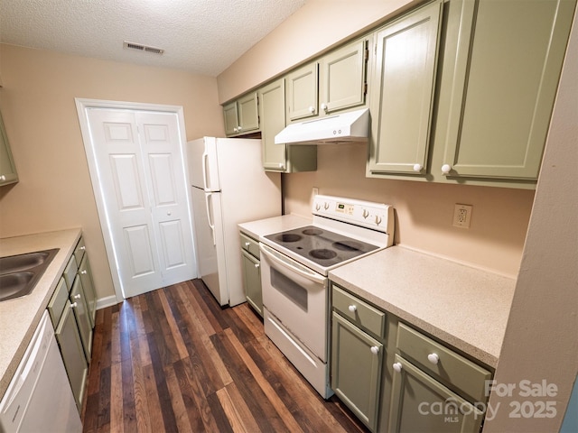 kitchen featuring dark wood finished floors, white appliances, green cabinetry, under cabinet range hood, and visible vents