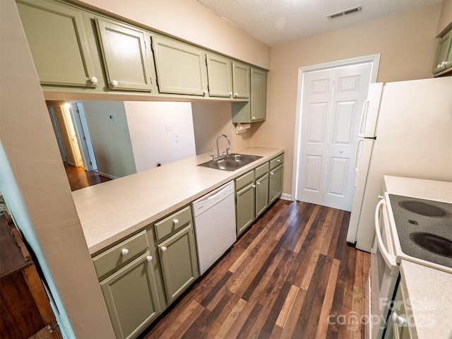 kitchen with green cabinetry, white appliances, light countertops, and a sink