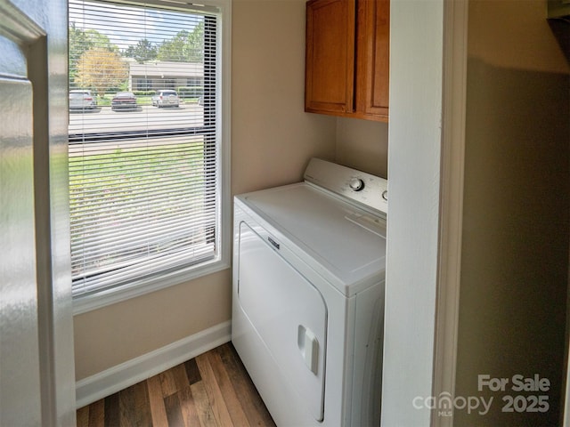 clothes washing area featuring dark wood-style floors, cabinet space, baseboards, and washer / clothes dryer