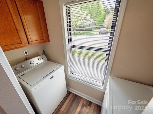 clothes washing area with dark wood-style floors, cabinet space, washer / dryer, and baseboards