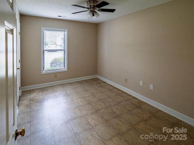 empty room featuring baseboards, visible vents, ceiling fan, and a textured ceiling