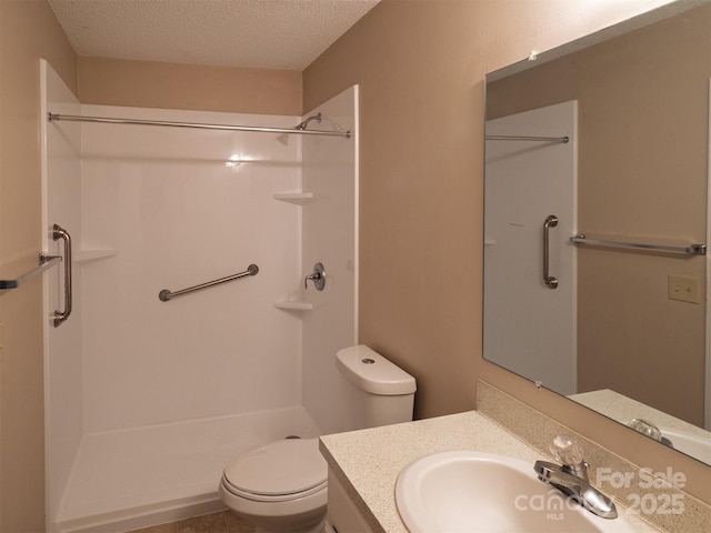 bathroom with toilet, a textured ceiling, walk in shower, and vanity