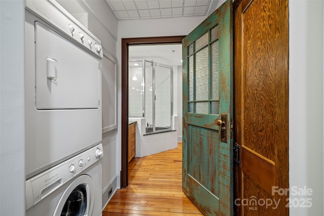 84 Walnut St Unit 203, Asheville, NC 28801 - clothes washing area with stacked washer / drying machine, light wood-style flooring, and laundry area