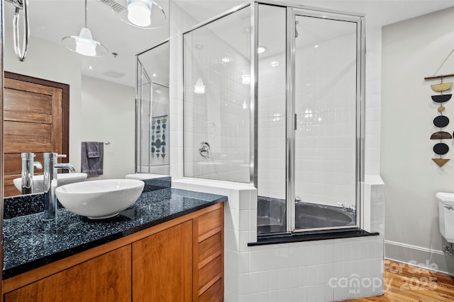 84 Walnut St Unit 203, Asheville, NC 28801 - bathroom featuring toilet, wood finished floors, vanity, and tiled shower