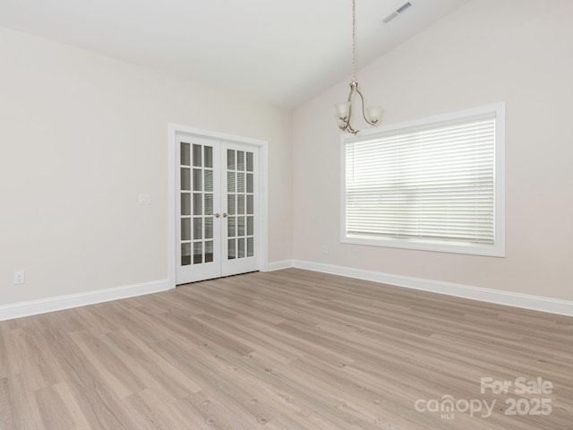 spare room featuring visible vents, an inviting chandelier, lofted ceiling, french doors, and light wood finished floors