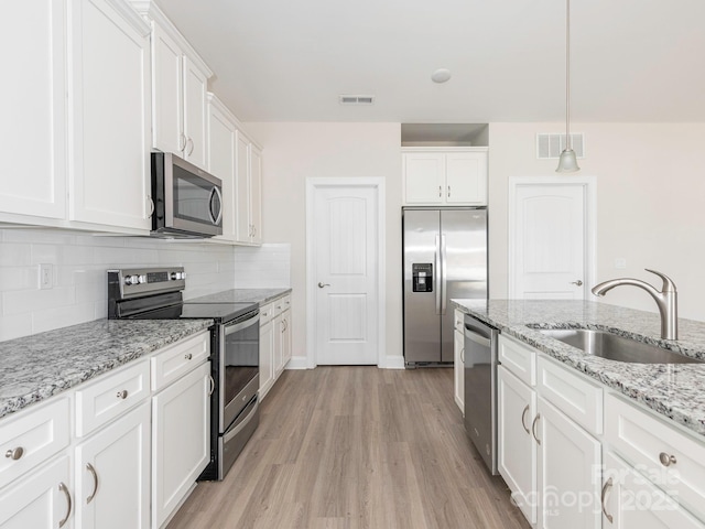 kitchen with white cabinetry, appliances with stainless steel finishes, a sink, and visible vents
