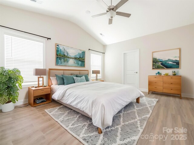 bedroom with baseboards, a ceiling fan, light wood-style flooring, and vaulted ceiling