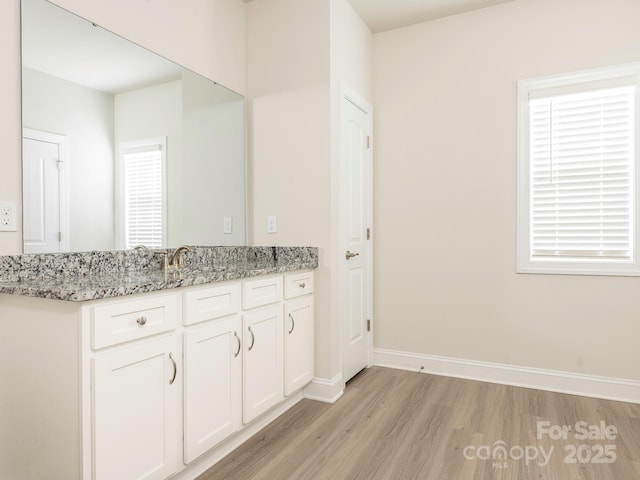 bathroom with vanity, baseboards, and wood finished floors