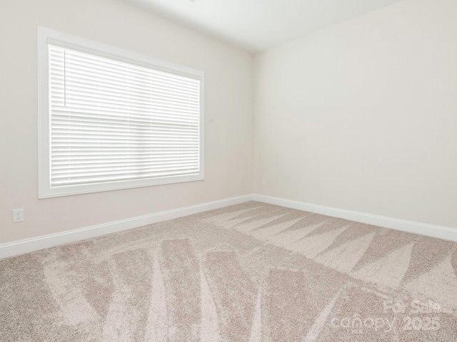 carpeted empty room with baseboards