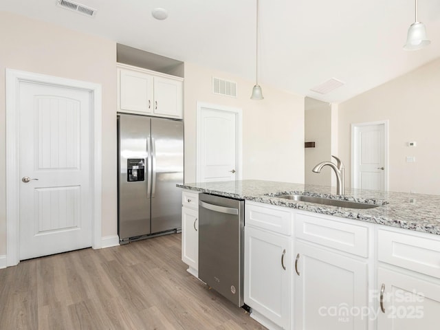 kitchen featuring appliances with stainless steel finishes, a sink, visible vents, and light wood-type flooring