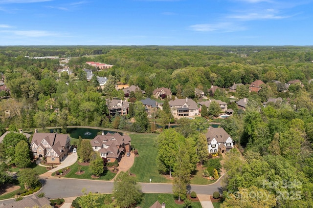bird's eye view featuring a wooded view and a residential view