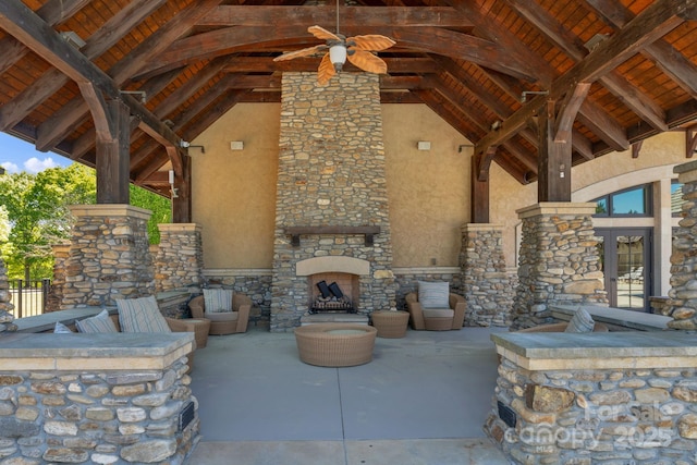 view of patio / terrace with a ceiling fan, an outdoor stone fireplace, and french doors
