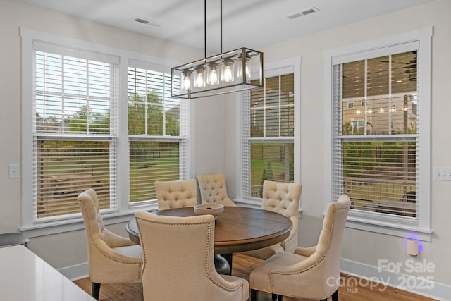 dining space featuring a notable chandelier, baseboards, and visible vents