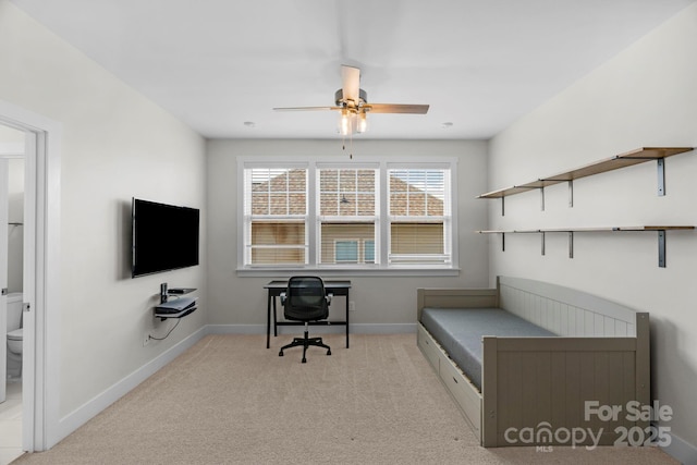 carpeted home office featuring baseboards and ceiling fan