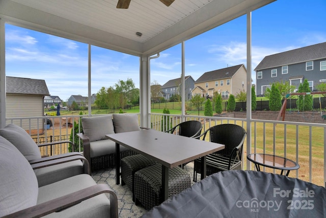 sunroom / solarium featuring an outdoor living space, a ceiling fan, a residential view, and a healthy amount of sunlight