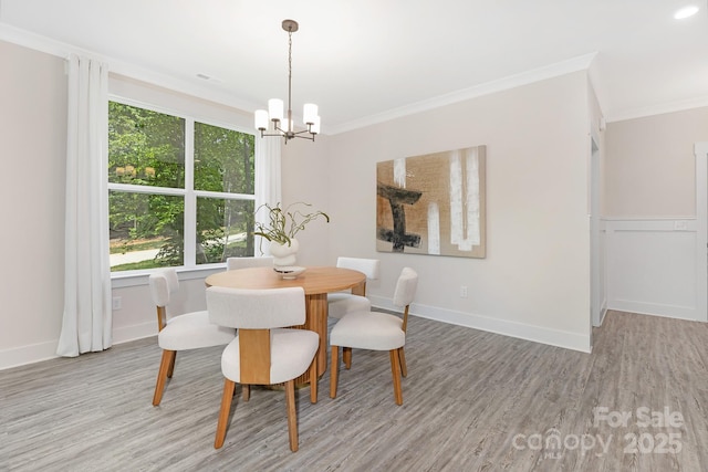 dining room with light wood-style floors, ornamental molding, a chandelier, and visible vents