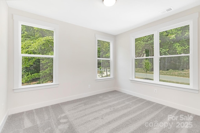 empty room with baseboards, carpet, and visible vents