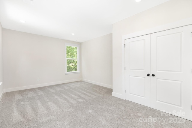 unfurnished bedroom with carpet flooring, recessed lighting, baseboards, and a closet