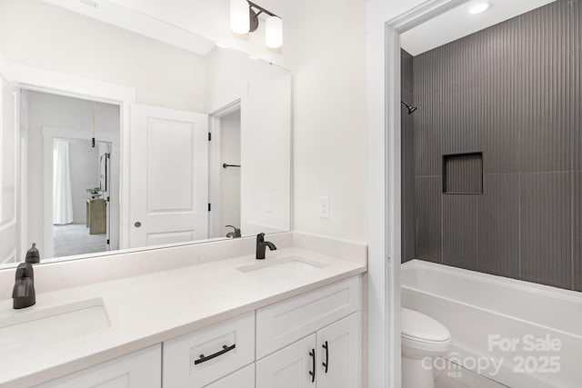 bathroom with double vanity, a sink, washtub / shower combination, and toilet