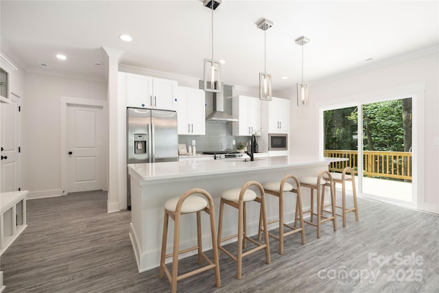8937 Penstemons Dr, Charlotte, NC 28215 - kitchen with wall chimney range hood, appliances with stainless steel finishes, tasteful backsplash, light wood-style flooring, and crown molding