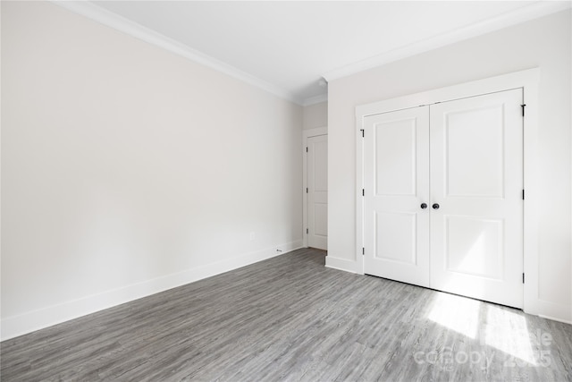 8937 Penstemons Dr, Charlotte, NC 28215 - unfurnished bedroom with wood finished floors, ornamental molding, and a closet