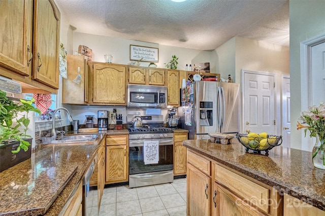 394 Runnymede Dr, Rock Hill, SC 29732 - kitchen featuring a sink, a textured ceiling, dark stone counters, stainless steel appliances, and light tile patterned flooring