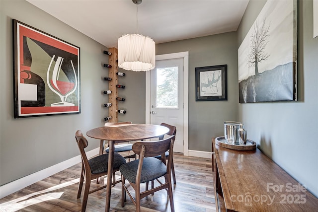 dining space featuring baseboards and wood finished floors