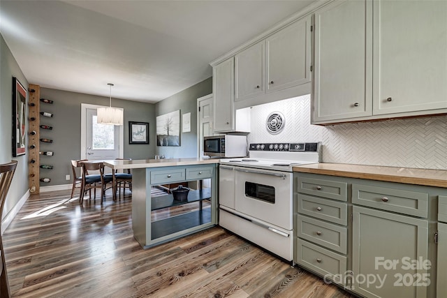 kitchen with light countertops, dark wood-style floors, stainless steel microwave, white electric range, and decorative backsplash