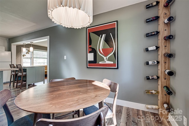 dining space with baseboards and wood finished floors
