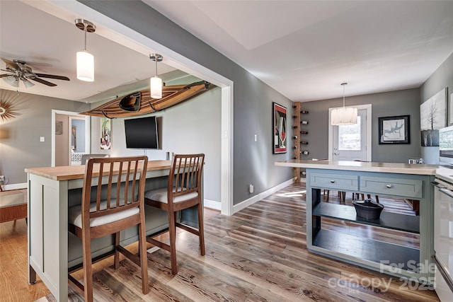 dining room with ceiling fan, baseboards, and wood finished floors