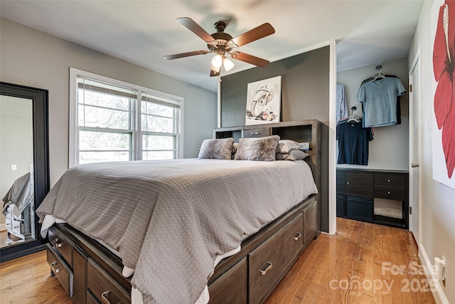 bedroom with light wood-type flooring, baseboards, and ceiling fan