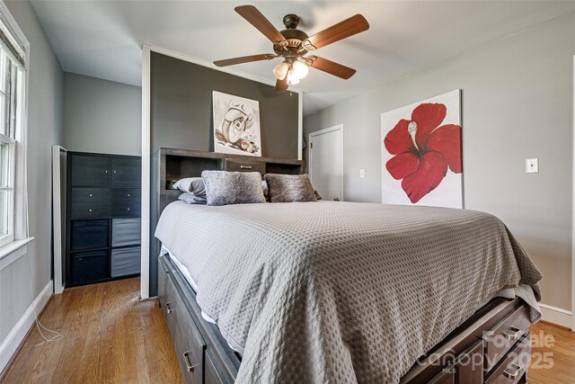 bedroom with baseboards, a ceiling fan, and wood finished floors