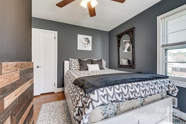 bedroom with wood finished floors, ceiling fan, and baseboards
