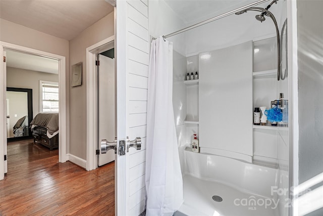 ensuite bathroom featuring wood finished floors, a shower with shower curtain, and ensuite bath