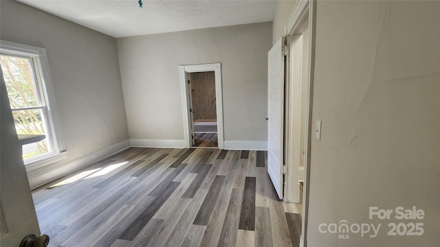unfurnished bedroom with baseboards and wood finished floors