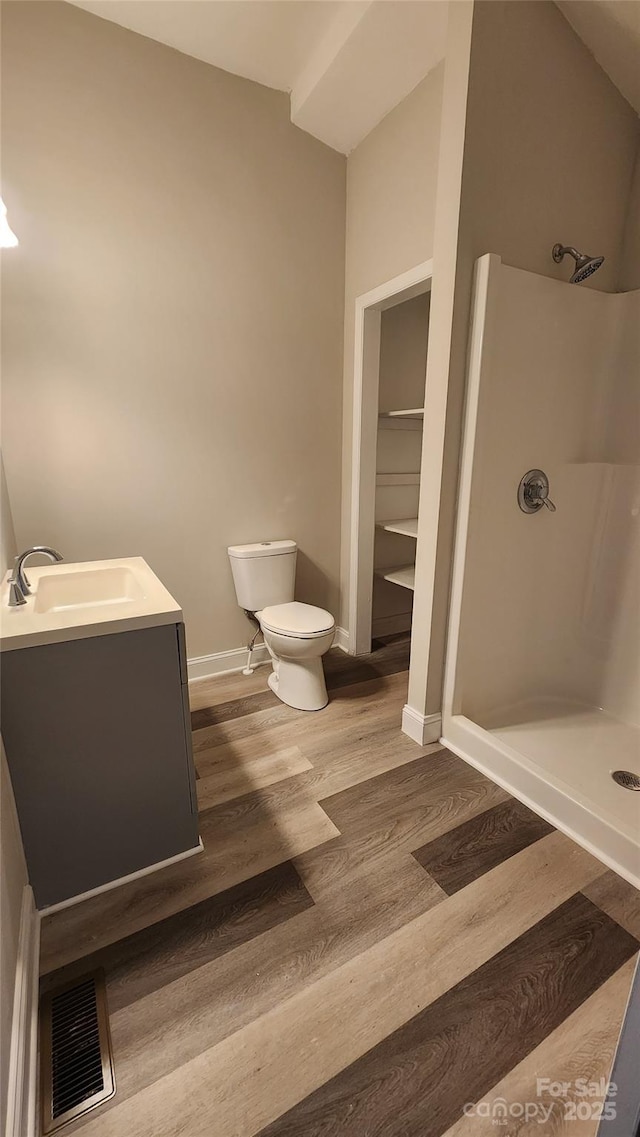 bathroom with a shower stall, visible vents, toilet, and wood finished floors