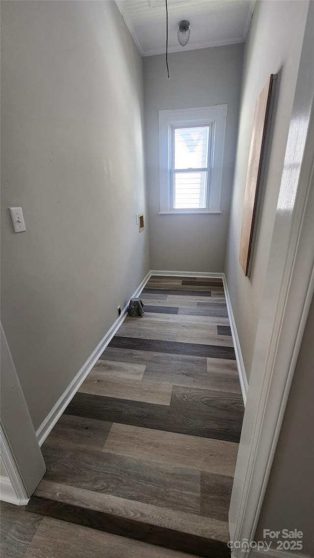 interior space with ornamental molding, baseboards, and wood finished floors
