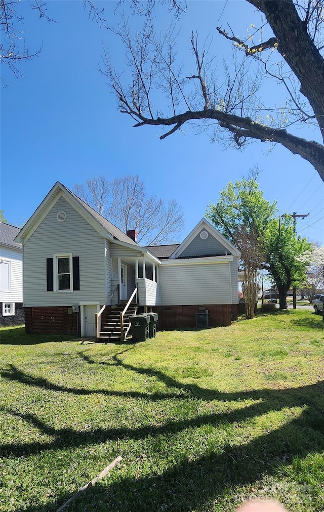 exterior space featuring cooling unit, a lawn, and a chimney
