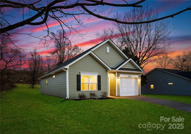 traditional-style home with a yard, a garage, and concrete driveway
