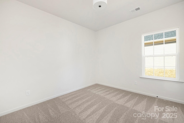 carpeted empty room featuring visible vents and baseboards