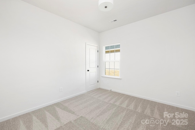 unfurnished room with visible vents, baseboards, and carpet
