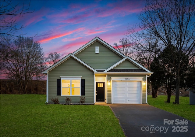 view of front facade with an attached garage, roof with shingles, a yard, and concrete driveway