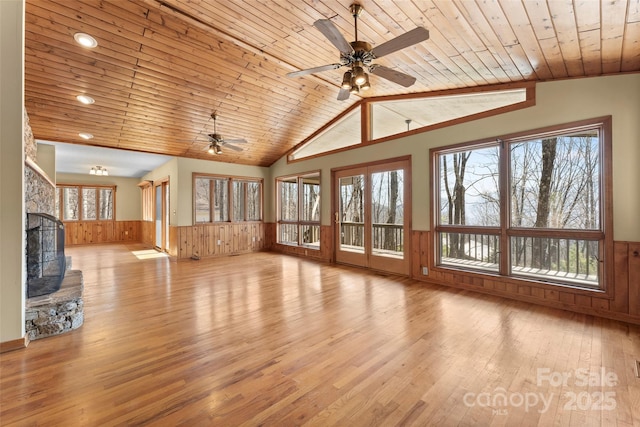 1 Sleepy Hollow Dr, Maggie Valley, NC 28751 - unfurnished living room featuring ceiling fan, vaulted ceiling, a stone fireplace, a wainscoted wall, and wood ceiling