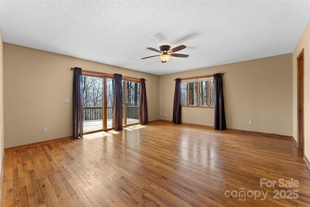 1 Sleepy Hollow Dr, Maggie Valley, NC 28751 - empty room featuring a textured ceiling, a ceiling fan, plenty of natural light, and light wood finished floors