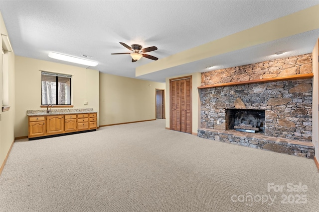 1 Sleepy Hollow Dr, Maggie Valley, NC 28751 - unfurnished living room featuring a sink, ceiling fan, a fireplace, a textured ceiling, and carpet flooring