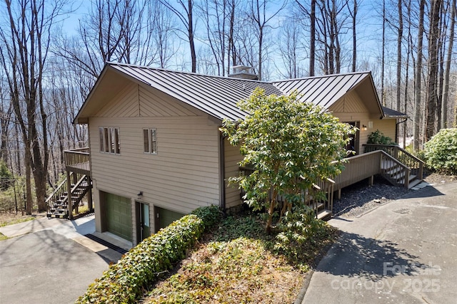 1 Sleepy Hollow Dr, Maggie Valley, NC 28751 - view of side of home with a chimney, an attached garage, aphalt driveway, a standing seam roof, and metal roof