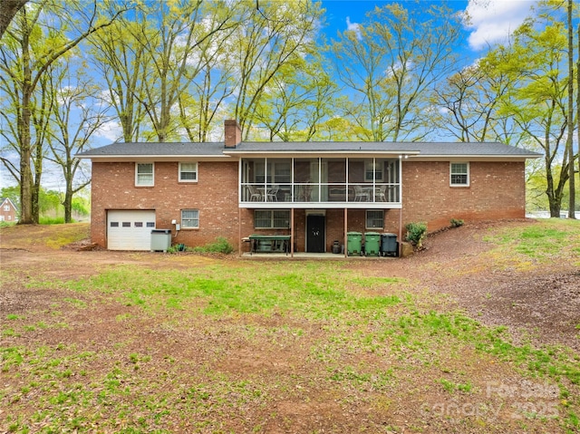 rear view of house featuring brick siding, an attached garage, a sunroom, and a chimney