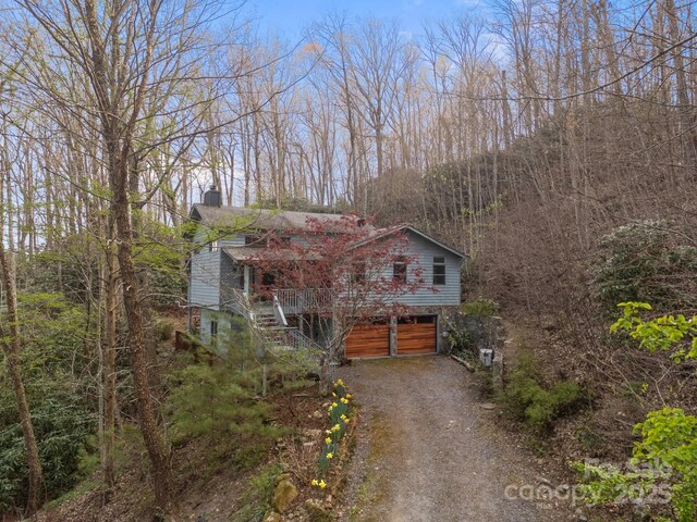 63 Chestnut Forest Rd, Fairview, NC 28730 - view of front facade featuring stairs, driveway, a forest view, and a chimney